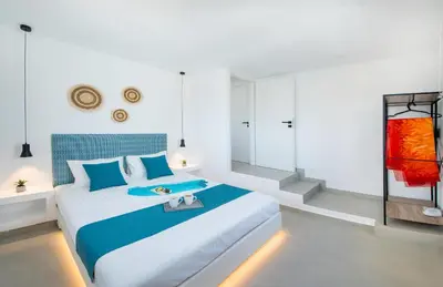 a white bedroom with a large bed with a tray on it at Blue Di Mare Villas in Lachania