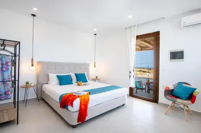 a bedroom with a large bed and a balcony at Blue Di Mare Villas in Lachania