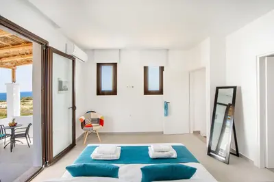 a bedroom with a bed and a large window at Blue Di Mare Villas in Lachania