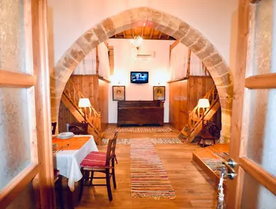 an archway in a room with a table and a piano at Villa Patitiri Traditional House with hot tub in Archangelos