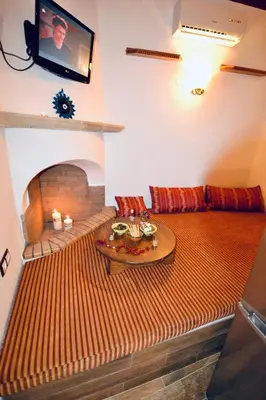 a living room with a couch and a table at Villa Patitiri Traditional House with hot tub in Archangelos