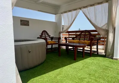 a room with a hot tub and a table and chairs at Villa Patitiri Traditional House with hot tub in Archangelos