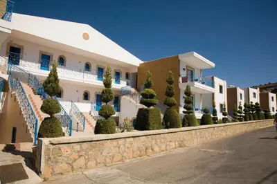 a building with a fence and trees in front of it at Pefki Islands in Pefki Rhodes