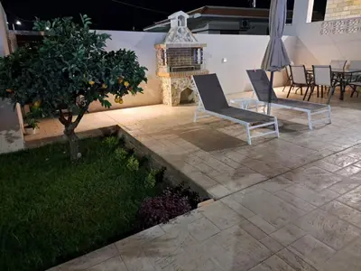 a patio with two chairs and a tree at Anastasia Luxury House in Afantou