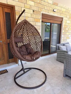 a wicker swing chair sitting on a patio at Anastasia Luxury House in Afantou