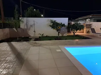 a house with a swimming pool at night at Anastasia Luxury House in Afantou