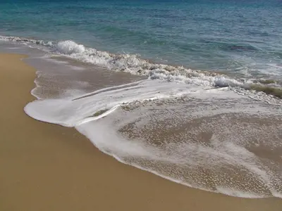 a beach with a wave breaking on the shore at Lindia Thalassa in Pefki Rhodes