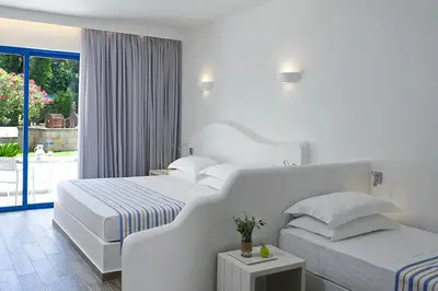 a white bedroom with two beds and a balcony at Lindia Thalassa in Pefki Rhodes