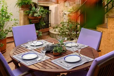 a wooden table with plates and wine glasses on it at Suite del Capitano in Rhodes Town