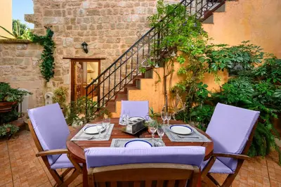 a wooden table and chairs on a patio at Suite del Capitano in Rhodes Town