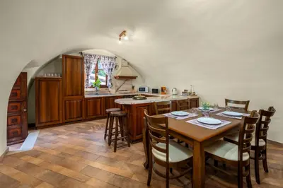 a kitchen with a wooden table with chairs and a kitchen with a counter at Suite del Capitano in Rhodes Town