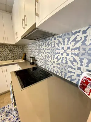 a kitchen with blue and white tiles on the wall at Cozy blue in Ialyssos