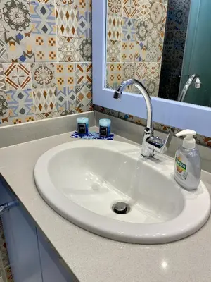 a white sink in a bathroom with a mirror at Cozy blue in Ialyssos