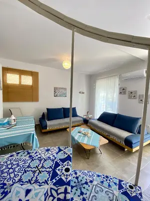 a living room with blue couches and a table at Cozy blue in Ialyssos