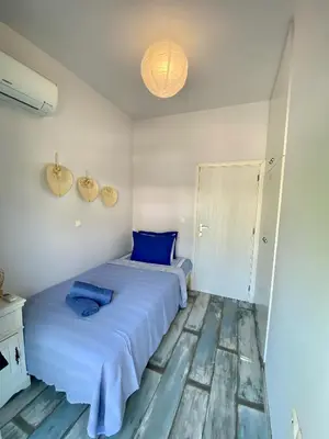 a bedroom with two beds with blue pillows at Cozy blue in Ialyssos