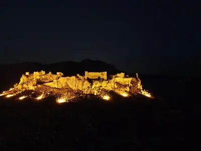 a castle on top of a mountain at night at Alia Beachfront Suites and Spa in Haraki