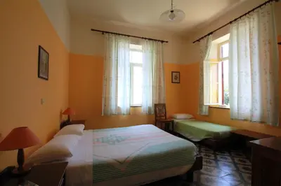 a bedroom with two beds and two windows at Hotel Anastasia in Rhodes Town