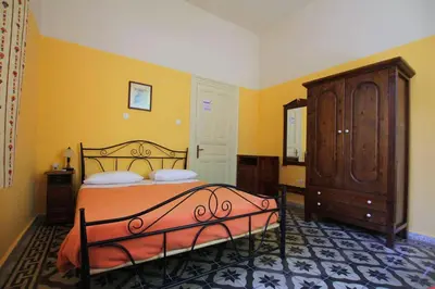 a bedroom with a bed and a wooden cabinet at Hotel Anastasia in Rhodes Town