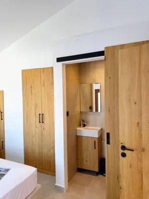 a room with a bed and a bathroom with a sink at Alindo Villa II, in Lindos area in Líndos