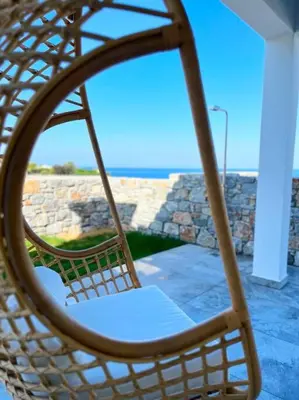 a swinging chair in a porch with a view of the ocean at Alindo Villa II, in Lindos area in Líndos