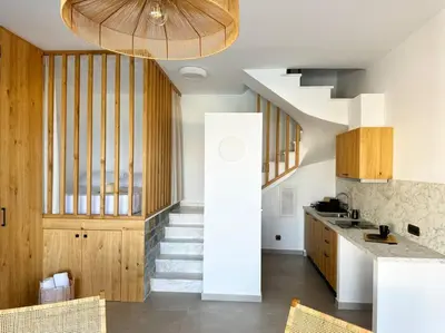 a kitchen with stairs leading up to a stair case at Alindo Villa II, in Lindos area in Líndos