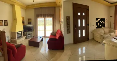 a living room with red chairs and a tv at Luna's Summer House in Kremasti