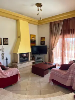 a living room with a fireplace and a tv at Luna's Summer House in Kremasti