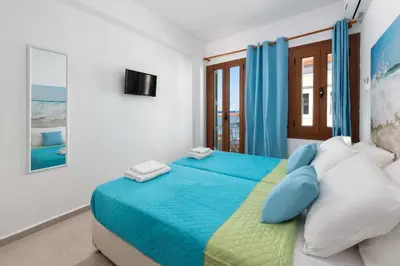 a bedroom with a bed with blue and white pillows at Elena in Symi