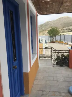 a door to a house with a view of the ocean at Nikolitsi Studios in Symi