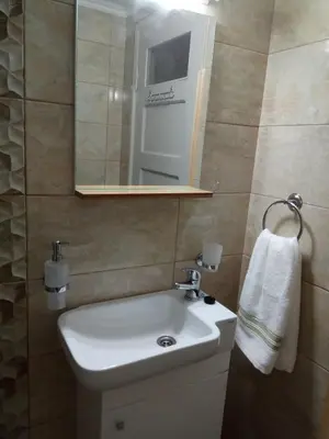 a bathroom with a white sink and a mirror at Nikolitsi Studios in Symi