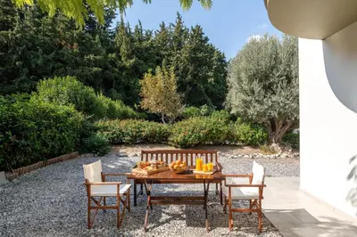 a wooden table and chairs with food on it at Cicada Villa in Koskinou