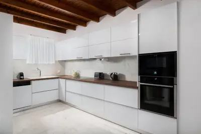 a kitchen with white cabinets and black appliances at Hamilton Sea Front Villa in Archangelos