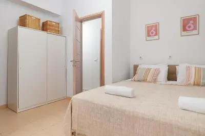 a white bedroom with a bed with two pillows on it at Hamilton Sea Front Villa in Archangelos