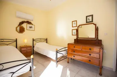 a bedroom with two beds and a dresser with a mirror at The Olive Grove Villa Private Pool with Sea & Sunset Views in Theologos