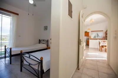 a bedroom with two beds and a hallway with a kitchen at The Olive Grove Villa Private Pool with Sea & Sunset Views in Theologos