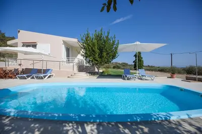 a swimming pool in front of a villa at The Olive Grove Villa Private Pool with Sea & Sunset Views in Theologos