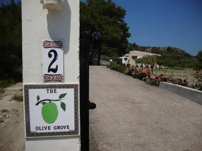 a sign that reads the olive groove on a building at The Olive Grove Villa Private Pool with Sea & Sunset Views in Theologos