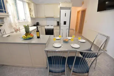 a kitchen with a table and chairs with glasses of wine at Nina's Apt in Ialysos near the Beach in Ialyssos