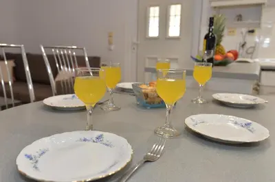 a table with plates and glasses of orange juice at Nina's Apt in Ialysos near the Beach in Ialyssos
