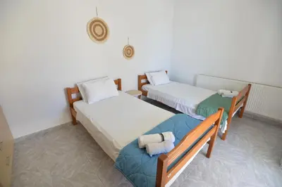 a room with two beds and a chair in it at Nina's Apt in Ialysos near the Beach in Ialyssos