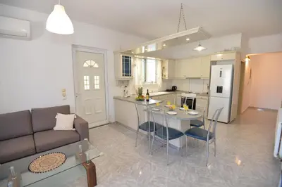 a living room and kitchen with a couch and a table at Nina's Apt in Ialysos near the Beach in Ialyssos