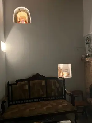 a room with a couch and a light on the wall at The Priest's Traditional House Kalithies in Kalithies