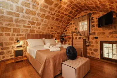 a bedroom with a bed in a stone wall at Medieval apartment Estiva in Rhodes Town