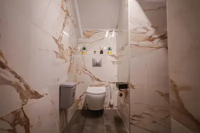 a bathroom with a white toilet and marble walls at Medieval apartment Estiva in Rhodes Town