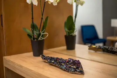 a wooden desk with two plants and a remote control at Rodi Luxury Apartment in Rhodes Town