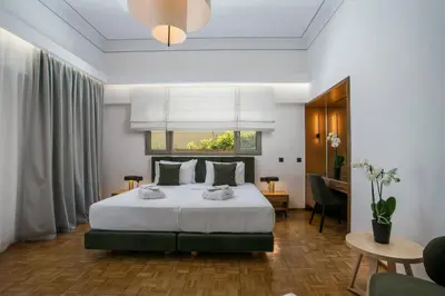 a bedroom with a large bed and a desk at Rodi Luxury Apartment in Rhodes Town