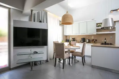 a kitchen with a table and chairs and a tv at Rodi Luxury Apartment in Rhodes Town
