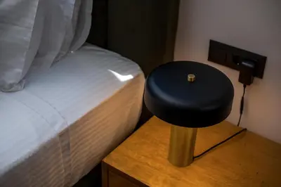 a stool sitting on a table next to a bed at Rodi Luxury Apartment in Rhodes Town