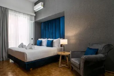 a hotel room with a bed and a chair at Rodi Luxury Apartment in Rhodes Town