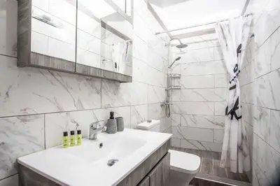 a white bathroom with a sink and a toilet at Kalimera Villa By the Sea in Gennadi